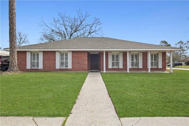 ranch-style house with brick siding, roof with shingles, and a front yard