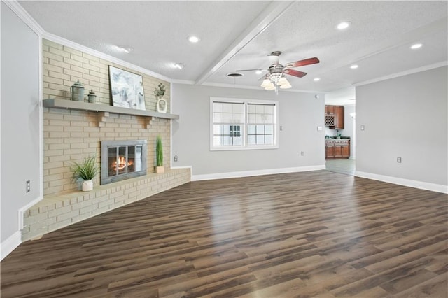 unfurnished living room featuring a brick fireplace, dark wood-style floors, ornamental molding, and a textured ceiling