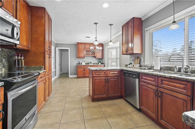 kitchen featuring pendant lighting, light tile patterned floors, appliances with stainless steel finishes, ornamental molding, and a sink