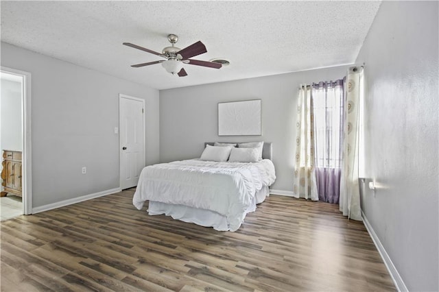 bedroom with ceiling fan, a textured ceiling, baseboards, and wood finished floors