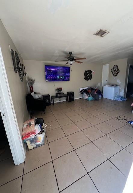 unfurnished living room featuring light tile patterned floors, ceiling fan, and visible vents