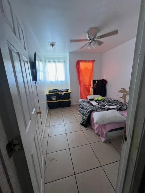 bedroom featuring light tile patterned floors, ceiling fan, and visible vents