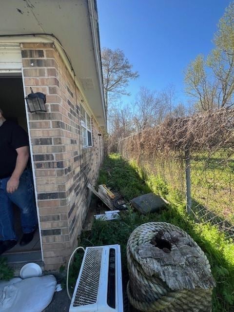 view of property exterior featuring central AC and brick siding