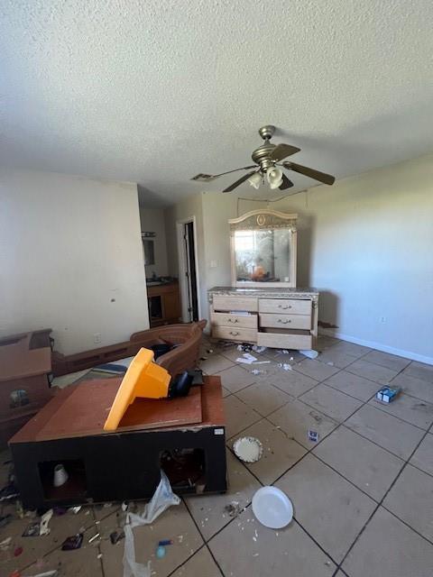 unfurnished bedroom featuring baseboards, tile patterned flooring, visible vents, and a textured ceiling