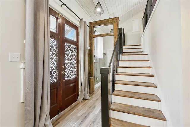 entrance foyer with french doors, stairway, and wood finished floors