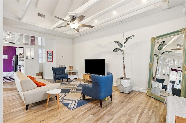 living area with light wood finished floors, baseboards, visible vents, and a ceiling fan