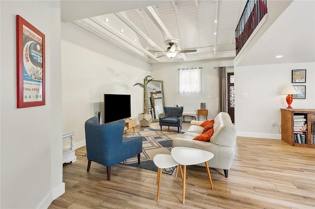 living room featuring a ceiling fan, wood finished floors, beam ceiling, and baseboards