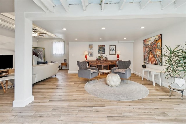 living room featuring baseboards, light wood-style flooring, ceiling fan, a bar, and recessed lighting