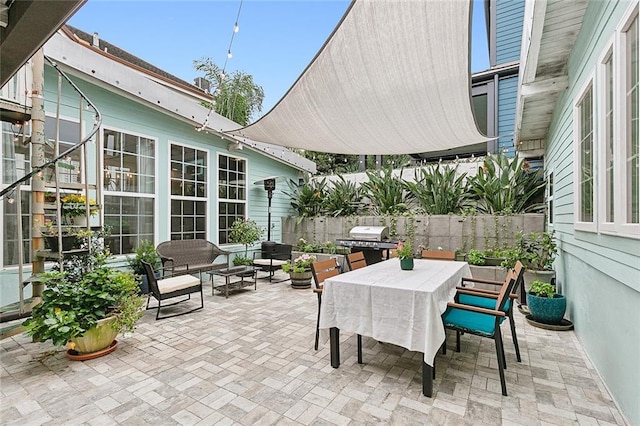 view of patio / terrace featuring outdoor dining area, a grill, fence, and an outdoor hangout area