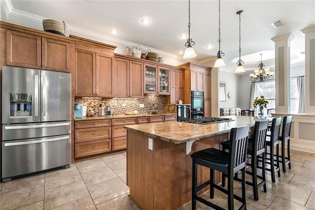 kitchen with stainless steel appliances, visible vents, brown cabinets, a center island, and tasteful backsplash