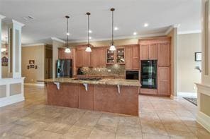 kitchen with brown cabinets, dobule oven black, a kitchen breakfast bar, and fridge