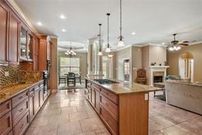 kitchen featuring a spacious island, recessed lighting, hanging light fixtures, backsplash, and glass insert cabinets