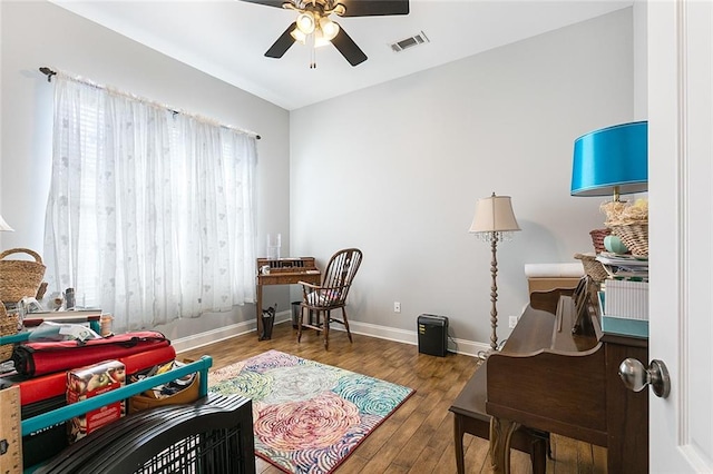 interior space with baseboards, visible vents, ceiling fan, and wood finished floors