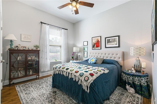 bedroom featuring ceiling fan, baseboards, and wood finished floors