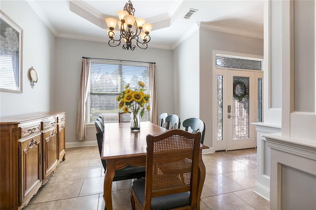 dining area with visible vents, a raised ceiling, ornamental molding, a notable chandelier, and light tile patterned flooring