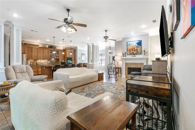 living area with a fireplace, decorative columns, recessed lighting, visible vents, and ceiling fan