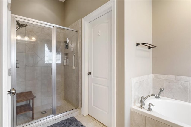 full bathroom featuring tile patterned flooring, a shower stall, and a bath