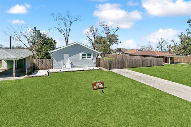 rear view of property featuring fence and a yard