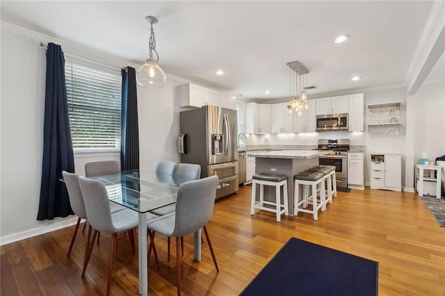 dining area with light wood finished floors, recessed lighting, visible vents, ornamental molding, and baseboards