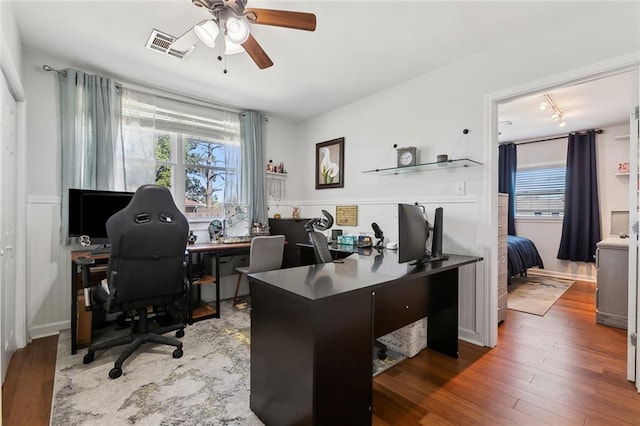 office with a ceiling fan, visible vents, and wood finished floors