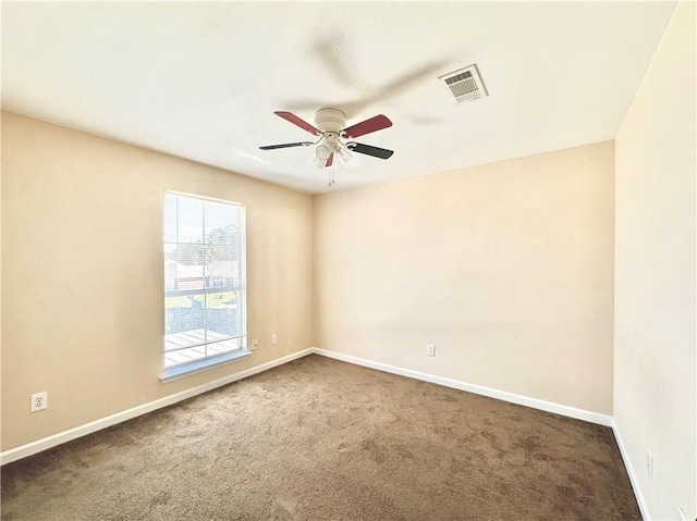 empty room featuring ceiling fan, carpet flooring, visible vents, and baseboards