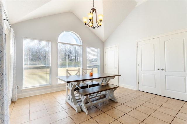 dining room featuring light tile patterned floors, baseboards, a chandelier, and high vaulted ceiling