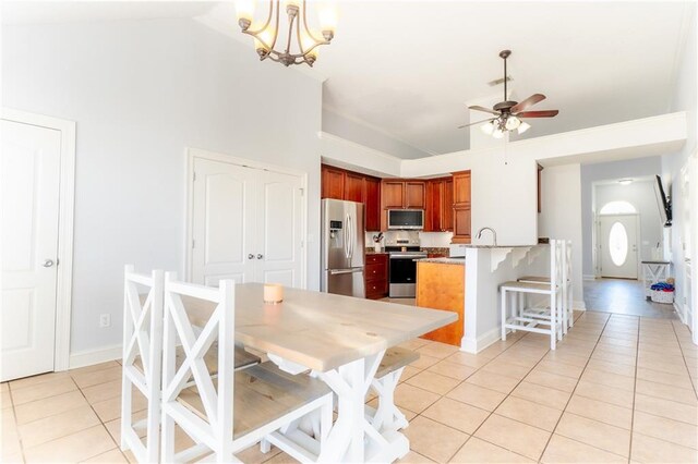 dining room featuring light tile patterned floors, high vaulted ceiling, ceiling fan with notable chandelier, and baseboards