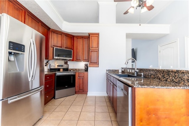 kitchen featuring crown molding, appliances with stainless steel finishes, light tile patterned flooring, a sink, and dark stone counters