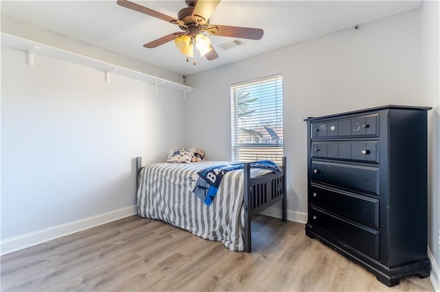 bedroom with ceiling fan, light wood-type flooring, visible vents, and baseboards