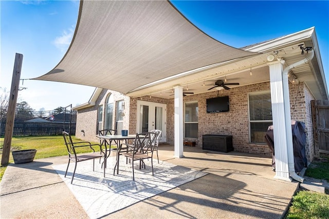 view of patio with french doors, outdoor dining area, fence, and a ceiling fan