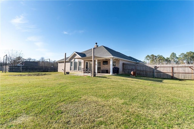 back of house with fence private yard, brick siding, a lawn, and a patio