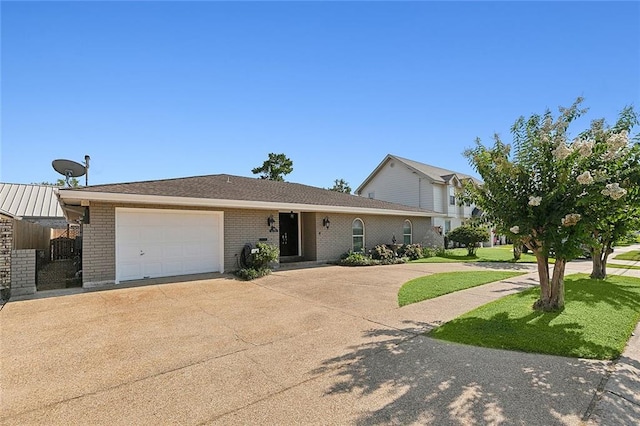 view of front of property with a garage, brick siding, driveway, and a front lawn