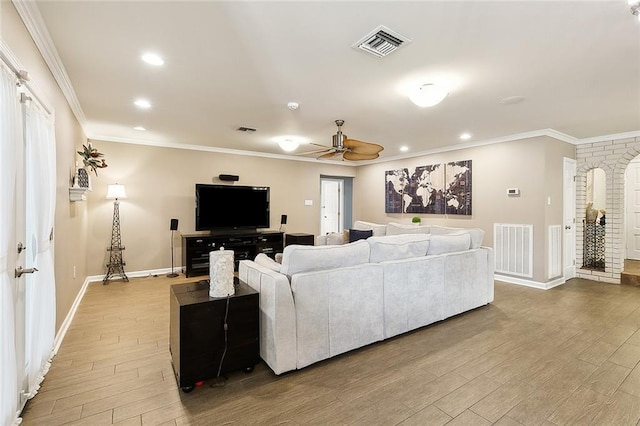 living area featuring ornamental molding and visible vents