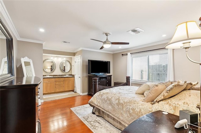 bedroom featuring light wood-style floors, visible vents, and crown molding