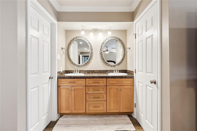 bathroom with crown molding, a sink, and double vanity