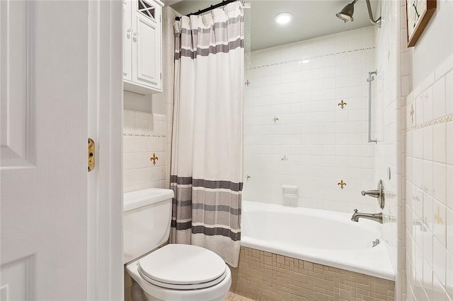 full bathroom with tiled shower / bath, tile walls, and toilet