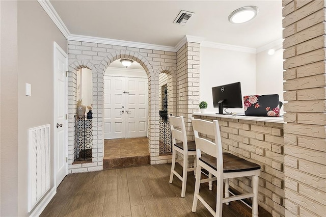 interior space featuring wood finished floors, visible vents, and crown molding