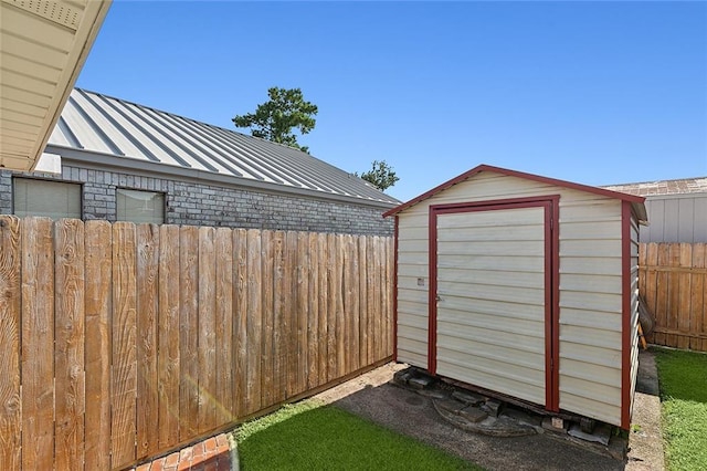 view of yard featuring an outbuilding, fence, and a shed