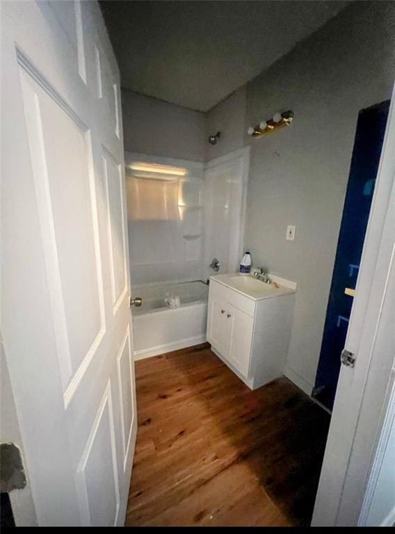 bathroom featuring vanity, wood finished floors, and shower / bathtub combination