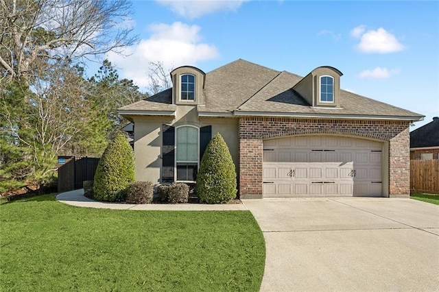 french country style house with concrete driveway, an attached garage, fence, a front yard, and brick siding