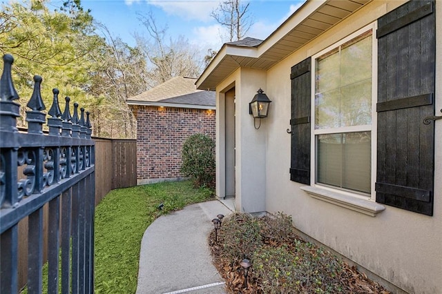 property entrance with fence and stucco siding