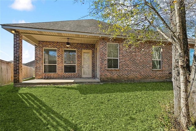 rear view of house featuring a yard, ceiling fan, fence, and a patio