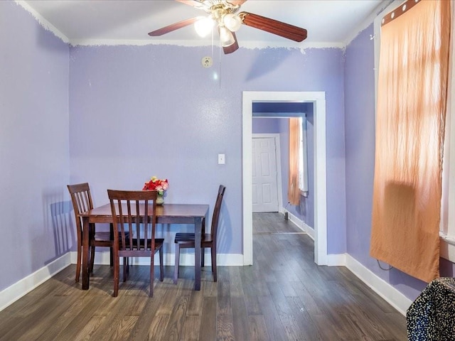 dining space featuring ceiling fan, baseboards, and dark wood-type flooring