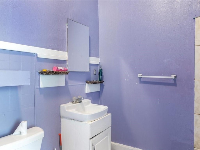 half bathroom featuring vanity and toilet
