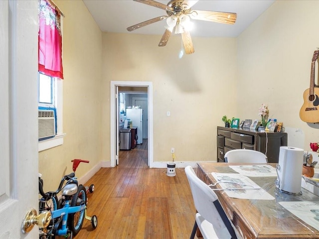 interior space featuring cooling unit, baseboards, ceiling fan, and hardwood / wood-style floors
