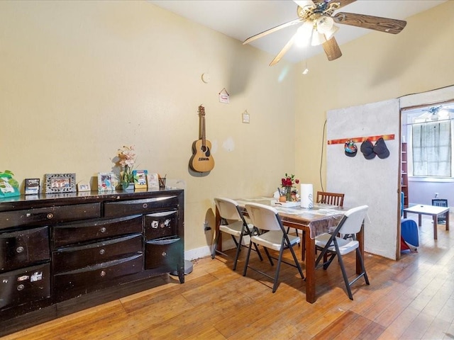 dining area with a ceiling fan, wood-type flooring, and baseboards