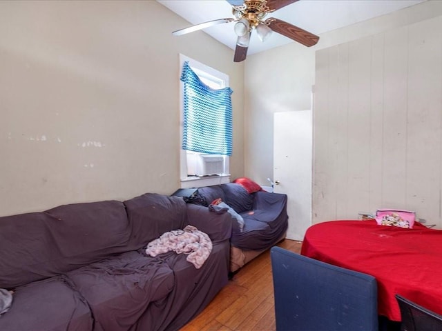 bedroom featuring cooling unit, a ceiling fan, and light wood-style floors