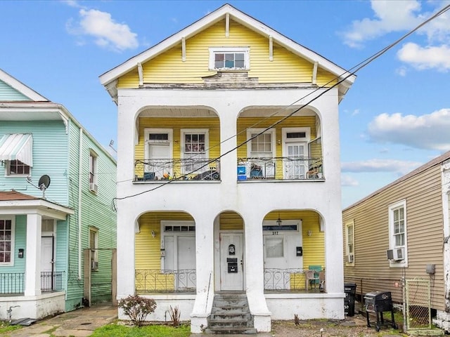 view of front of house featuring cooling unit, covered porch, and a balcony