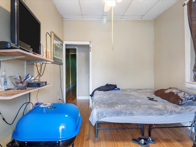 bedroom featuring a paneled ceiling and wood finished floors