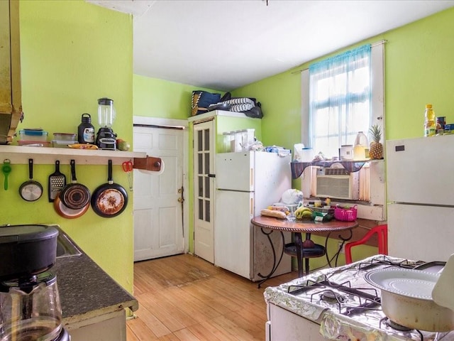 kitchen featuring wood finished floors and freestanding refrigerator